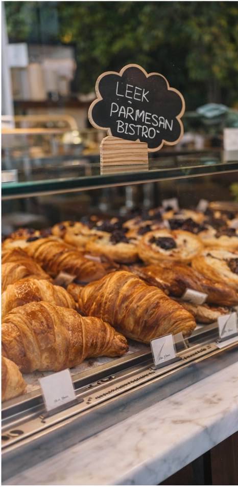 Pastry display case with fresh croissants, danishes and muffins at Le Réveil bakery, NYC
